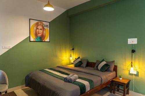 a bedroom with a bed with a picture on the wall at Whoopers Hostel Bir in Bīr