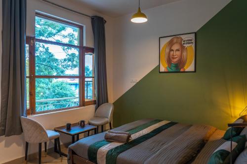 a bedroom with a bed and a table and a window at Whoopers Hostel Bir in Bīr