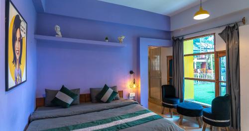 a blue bedroom with a bed and a window at Whoopers Hostel Bir in Bīr