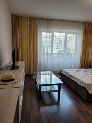 een hotelkamer met een bed en een glazen tafel bij Peaceful Loft in Boekarest