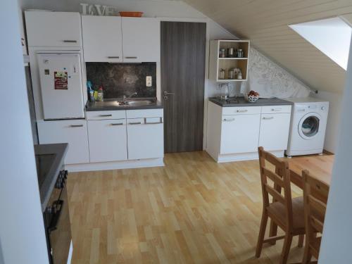 a kitchen with white appliances and a wooden floor at Allgäu Spirit in Immenstadt im Allgäu