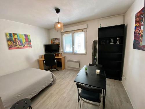 a bedroom with a bed and a desk and a deskablish at Studio le République in Dijon