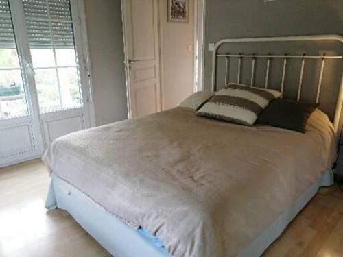 duże łóżko w sypialni z oknem w obiekcie Villas Jabron Sisteron w mieście Sisteron