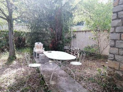 patio ze stołem i krzesłami na podwórku w obiekcie Villas Jabron Sisteron w mieście Sisteron