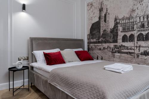 a bedroom with a large bed with red pillows at Apartament w centrum Krakowa 109 in Kraków