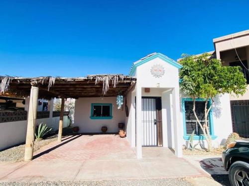 uma pequena casa branca com um telhado azul em Relax in the Charming Casita Mezquites #5 em Puerto Peñasco