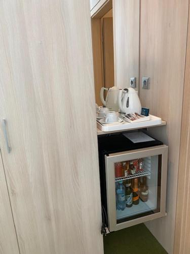 a small refrigerator with a tea kettle on top of it at Hotel Armatti in Braşov