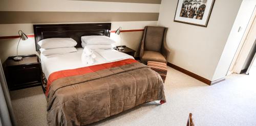 a hotel room with a bed and a chair at Indaba Hotel, Spa & Conference Center in Johannesburg