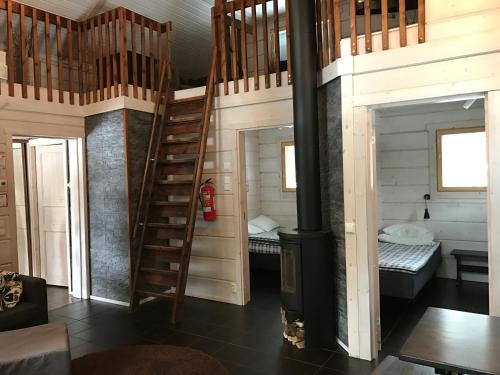 a wooden room with a staircase and two beds at Villa Tumppu in Jämsä