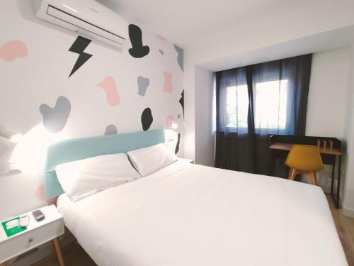 a bedroom with a white bed and a wall with hearts at Hostal Carmen by gaiarooms in Salamanca