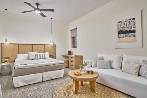 ein Schlafzimmer mit einem Bett und einem Sofa in der Unterkunft Voya Sifnos Mindful Stay in Kamarai