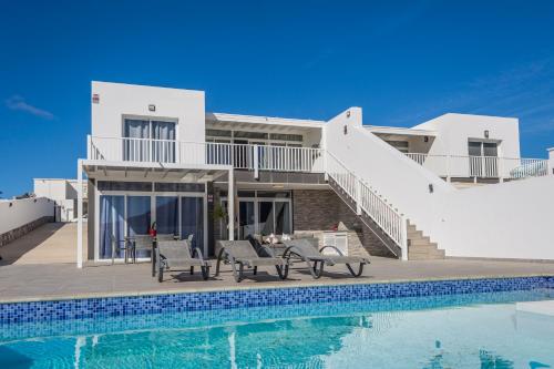 eine Villa mit einem Pool und einem Haus in der Unterkunft Villa Carol in Playa Blanca
