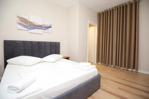 a bedroom with a large white bed and a large window at Hotel Amantia in Orikum