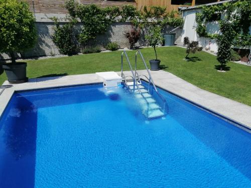 a blue swimming pool with a slide in a yard at Haus Thomas in Telfs