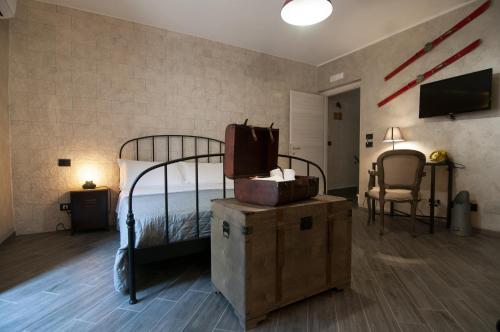 ピアッツァ・アルメリーナにあるPrincipe Giardinelliのベッド1台、荷物、テレビが備わる客室です。