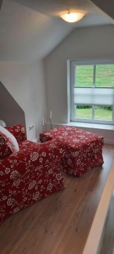 a bedroom with a red bed and a window at Ferienhaus Deichblick in Tönning