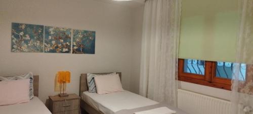 - une chambre avec 2 lits et un tableau mural dans l'établissement Virginia Apartment, à Thessalonique