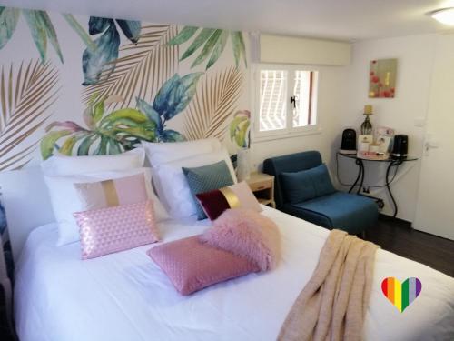 sypialnia z dużym białym łóżkiem z kolorowymi poduszkami w obiekcie Villa Bayarde w mieście Figanières