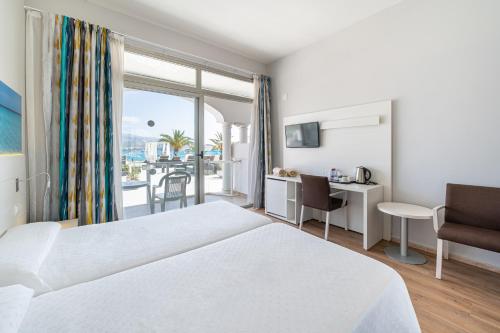 a hotel room with two beds and a balcony at Seramar Hotel Comodoro Playa in Palmanova