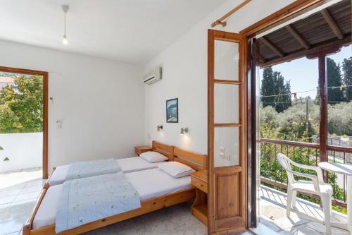 a bedroom with a bed and a large window at Platanakia in Skopelos Town