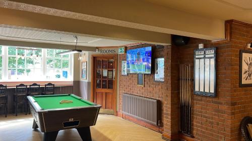 a pool table in a room with a brick wall at The Grey Horse in Darlington