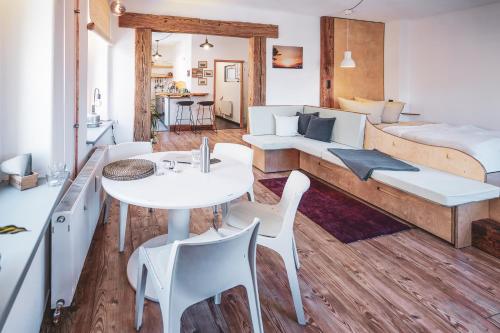a room with a white table and chairs and a bed at Studio Apartment zur alten Post, 48qm Individualapartment mit Blick über Zittaus Altstadt, Ferienwohnung im Altstadtkern umrandet vom Zittauer Gebirge in Zittau