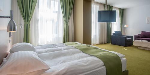 a hotel room with a large bed and a couch at Hotel Armatti in Braşov