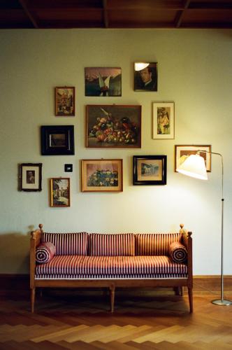 a couch against a wall with pictures on it at Signau House & Garden Boutique Hotel Zürich in Zürich