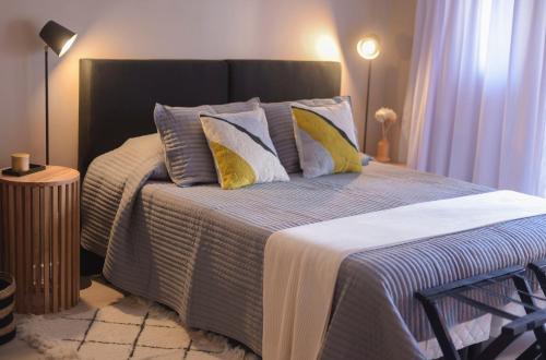 1 dormitorio con 1 cama grande con almohadas azules y amarillas en Chic Studio en Retiro en Buenos Aires