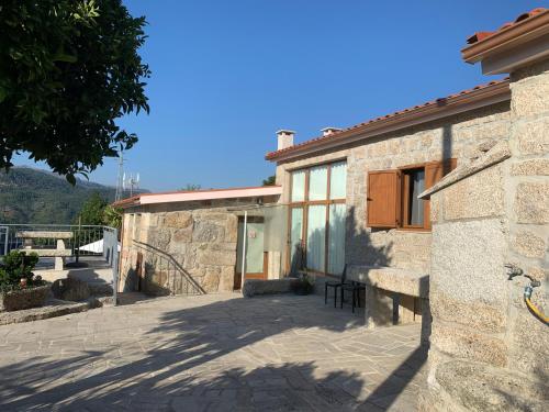 een stenen gebouw met een bank ervoor bij Casa da Lage - Lindas vistas - Gerês - Rio - Campo in Geres