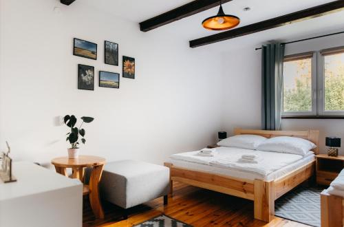 a bedroom with a bed and a chair and a window at Domki nad potokiem in Susiec