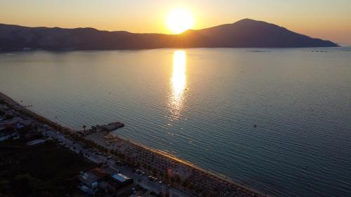 an aerial view of the sun setting over a body of water at Hotel Amantia in Orikum