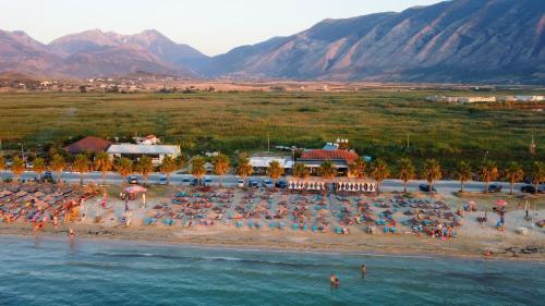 a beach with a bunch of umbrellas and people at Hotel Amantia in Orikum