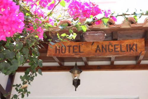 a sign that reads hotel angelica on a shelf with flowers at Hotel Angeliki in Iraion