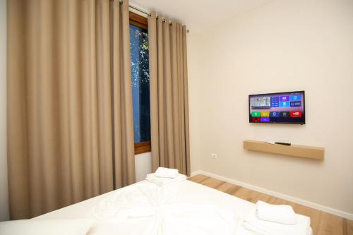 a bedroom with a bed and a tv on a wall at Hotel Amantia in Orikum