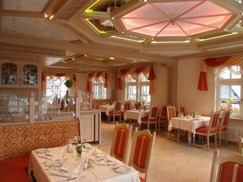 a restaurant with tables and chairs and a ceiling at Hotel Zum weißen Stein in Kirchen