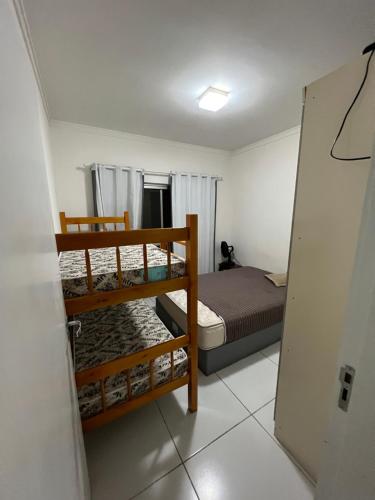 a bedroom with two bunk beds and a door open at Apto Central para Família in Balneário Camboriú