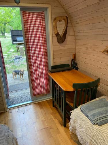 un comedor con una mesa y un perro al aire libre en New Acre Pod, en Angmering