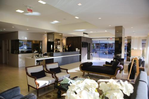 a living room with a couch and chairs and a counter at Blue Hill Hotel in Timbó
