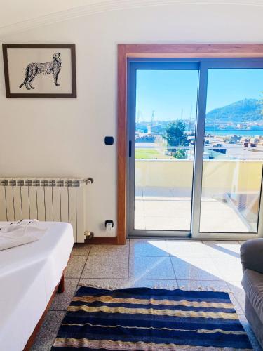 a bedroom with a bed and a large glass door at Cabedelo guest house in Viana do Castelo