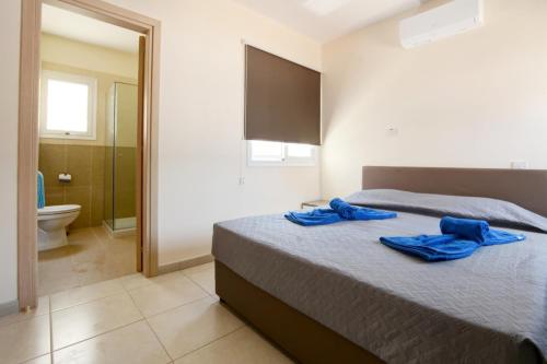 a bedroom with a bed with blue towels on it at Villa Nissi Gold in Ayia Napa