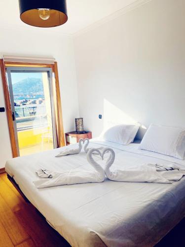 a bed with two heart shaped towels on it at Cabedelo guest house in Viana do Castelo