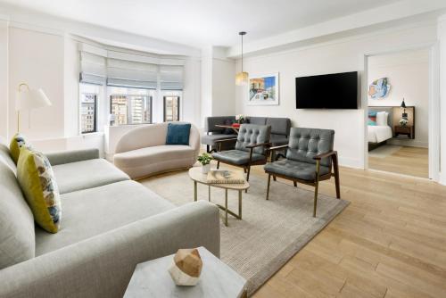 a living room with a couch and chairs and a tv at Hotel Seville NoMad - The Unbound Collection by Hyatt in New York