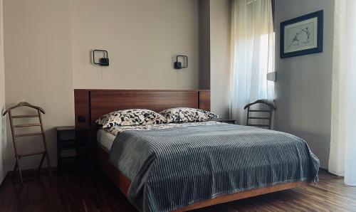 1 dormitorio con 1 cama con cabecero de madera y ventana en City Center Apartment, en Katowice