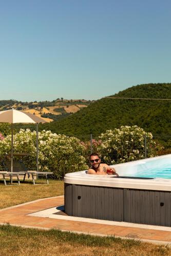 a man in a jacuzzi in a pool at Tenuta Borgo Santa Cecilia in Gubbio