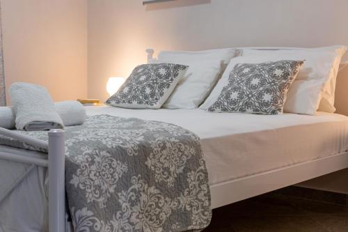 Una cama blanca con almohadas y una manta. en John Apartments, en Dhrepanon