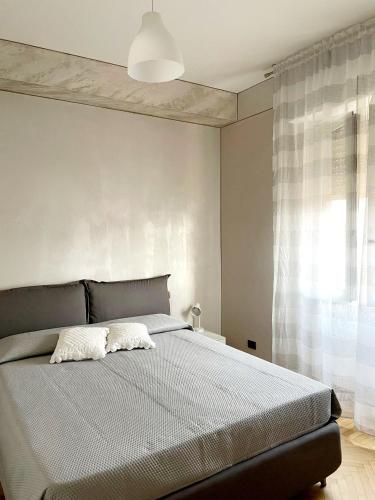 1 dormitorio con 1 cama con 2 almohadas en Attico Guest House, en Cremona