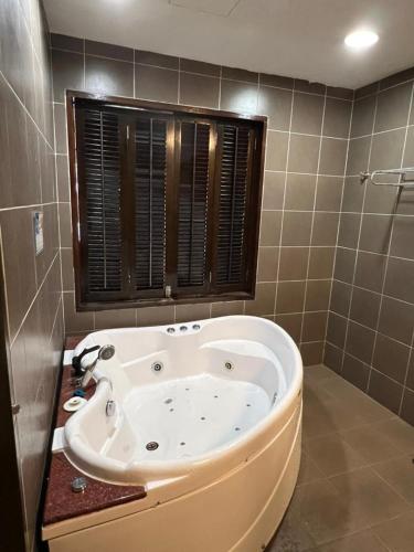 a bath tub in a bathroom with a window at Relax At Gold Coast Morib in Banting