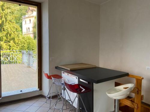 a kitchen with a counter with stools and a window at Apartment with Big Terrace and Direct access to the Beach in Varenna