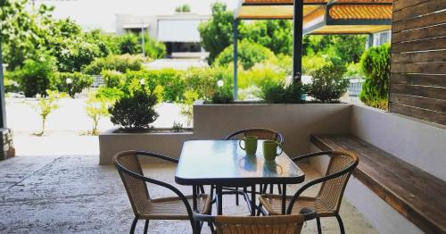 einen Tisch und Stühle auf einer Terrasse mit Aussicht in der Unterkunft Petries Studios in Agio Apóstoloi